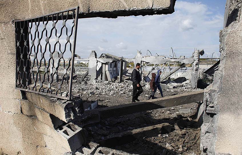 Палестинцы осматривают последствия израильского авиаудара в Рафахе