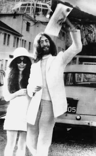 Джон Леннон и Йоко Оно поженились 20 марта 1969 года в Гибралтаре. После женитьбы Джон Леннон сменил свое второе имя Уинстон на Оно — теперь его звали Джон Оно Леннон. Медовый месяц пара провела в Европе&lt;br> На фото: Джон Леннон размахивает свидетельством о браке после свадьбы с Йоко Оно