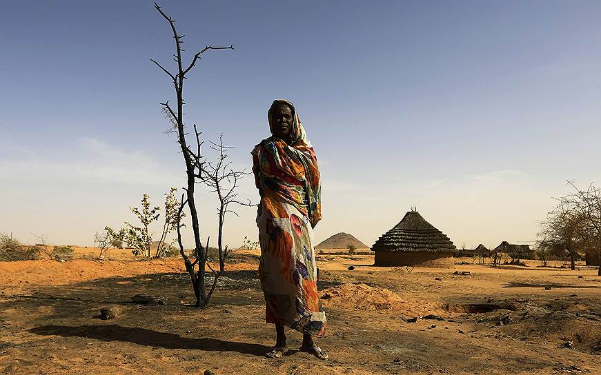 Жительница суданского Меллита на месте, где раньше был дом, сгоревший в ходе атаки повстанцев