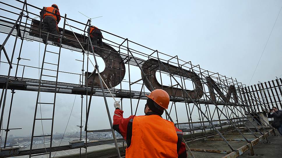 Рабочие снимают вывески «Москвич» и АЗЛК с крыши здания автозавода