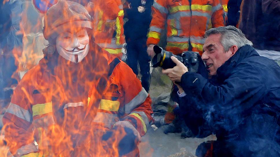 Бельгийский пожарный в маске Гая Фокса во время акции протеста в Брюсселе