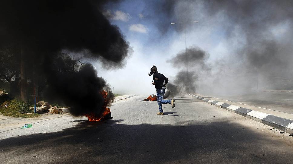 Палестинский демонстрант во время столкновений с израильскими военными в Рамаллахе