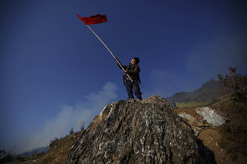 Житель непальской деревни Баса подает сигнал садящемуся вертолету