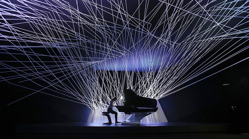 Музыкант играет на фортепиано, созданном дизайнерами компании Peugeot, на открытии Миланской ярмарки дизайна
