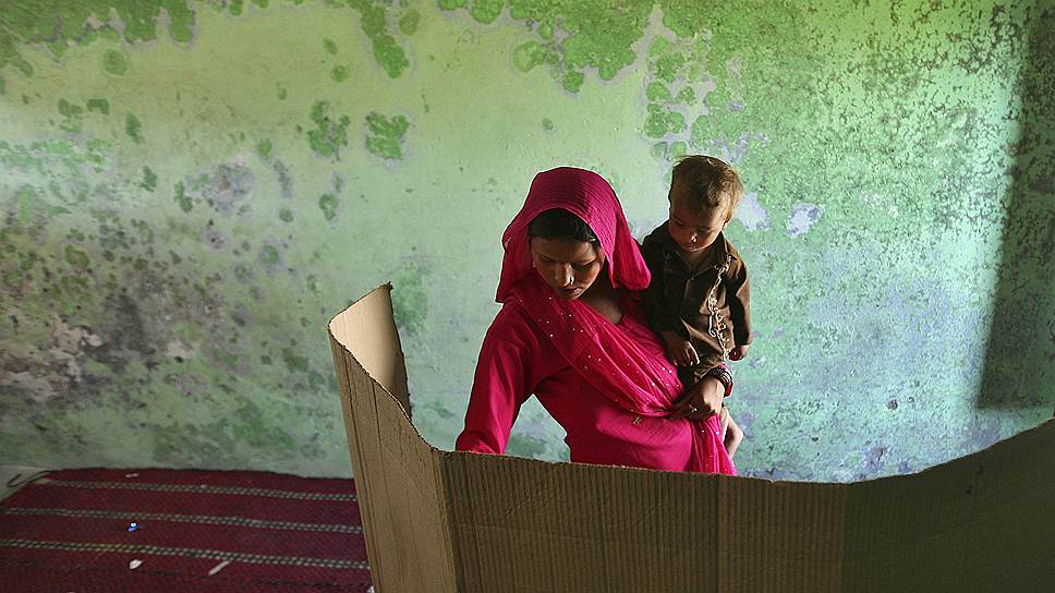 Индийская женщина голосует на избирательном участке на окраине Джамму