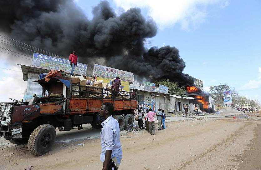 Сомалийские торговцы эвакуируют товары из магазинчиков, расположенных рядом с загоревшейся АЗС в Могадишо