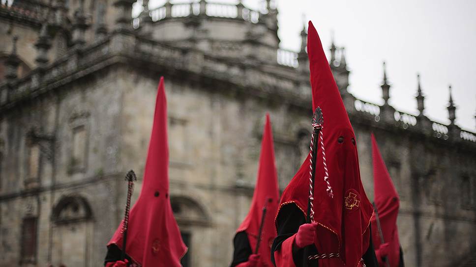 Страстная неделя в Испании. Католики принимают участие в традиционной процессии братства «Ла-Пас». На Страстной неделе участники процессий ежедневно выходят на улицы одетые в длинные туники цвета братства, перчатки и конусообразные колпаки с прорезями для глаз