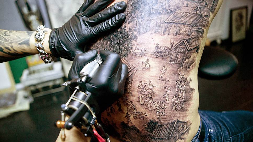 Тату-мастер в Чжучжоу наносит на спину клиента татуировку по мотивам знаменитой панорамы XII века «По реке в День поминовения усопших»