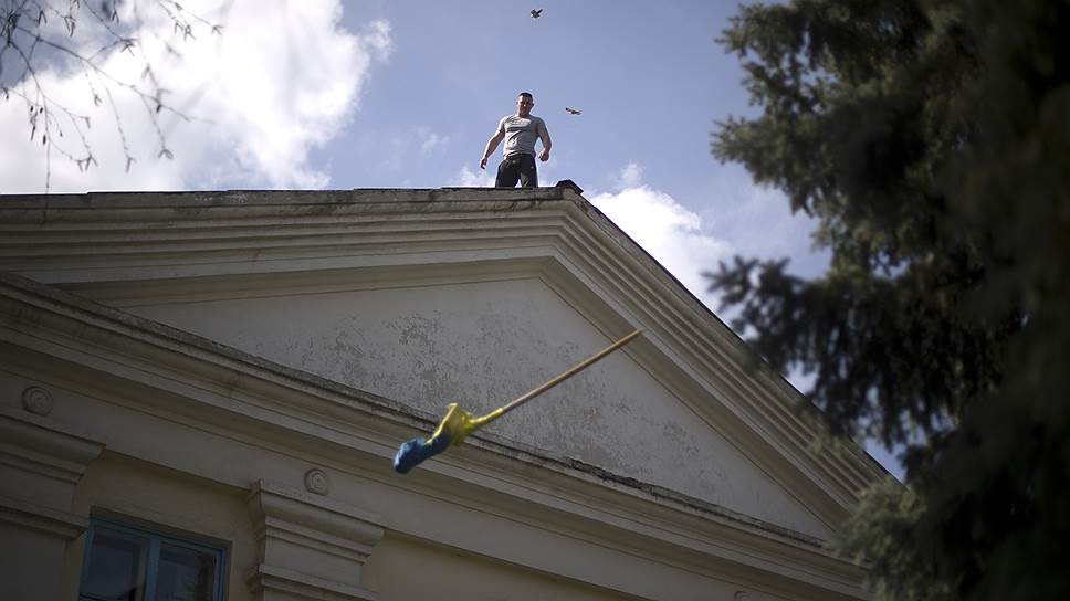 Пророссийский активист сбрасывает флаг Украины с крыши здания Северского горсовета, Донецкая область