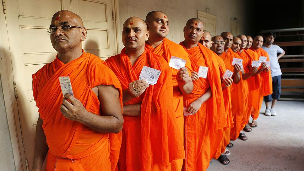 Индуистские монахи в очереди на избирательном участке во время выборов в парламент в Ахмадабаде, Индия