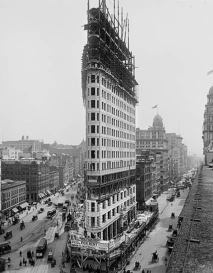 До конца XIX века строить здания высотой более шести этажей по многим причинам (в первую очередь, экономическим) было невыгодно. Когда же стоимость земли в США возросла в несколько раз, было принято решение построить здание, которое занимало бы меньшую площадь, но при этом вмещало большее количество людей&lt;br> На фото: «Флэтайрон-билдинг» в Нью-Йорке