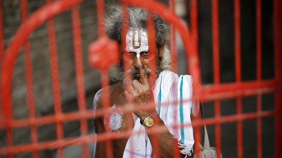 Индийский садху показывает палец, окрашенный специальными чернилами после голосования в Айодхе, штат Уттар-Прадеш