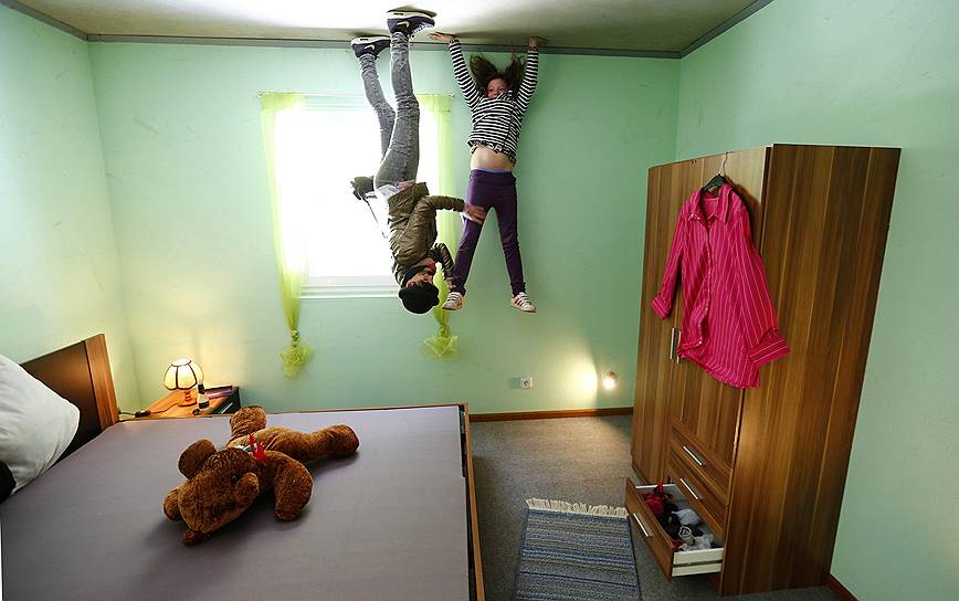 Туристы позируют внутри «перевернутого дома» в Аффолдерне, Германия