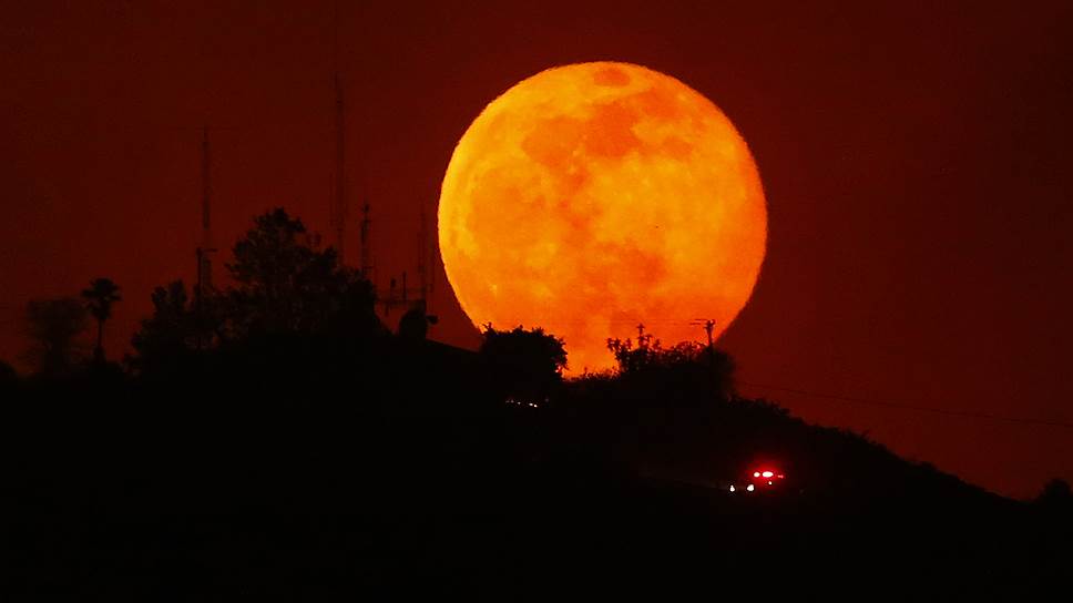 Восходящая луна над сгоревшим во время лесных пожаров холмом в Сан-Маркосе, штат Калифорния