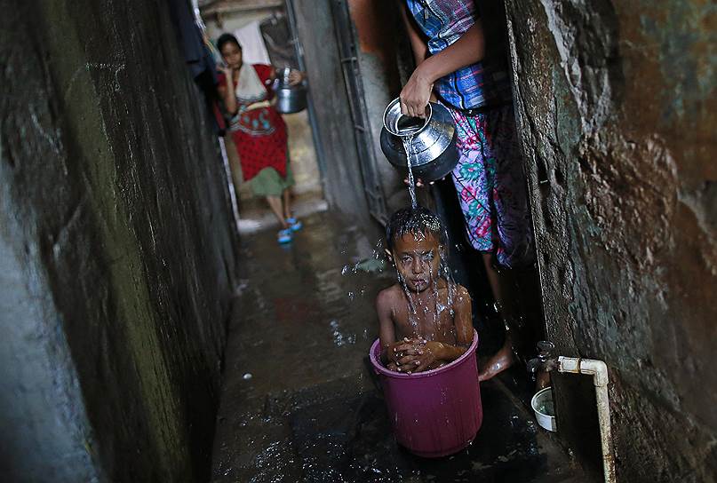 Купание ребенка в трущобах Мумбаи