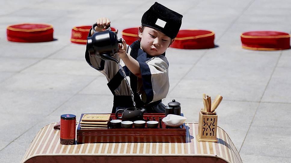 Юный китаец проводит чайную церемонию во время фестиваля в Шэньяне, провинция Ляонин