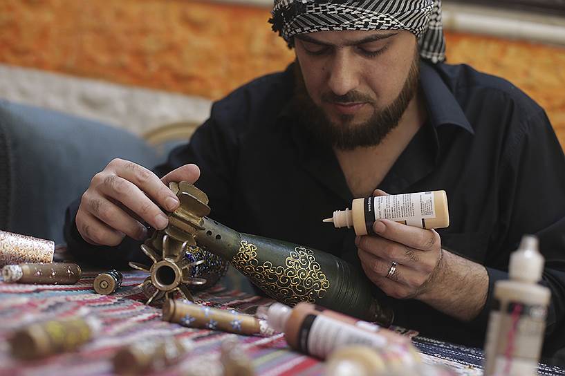 Сириец раскрашивает минометные снаряды в Дамаске