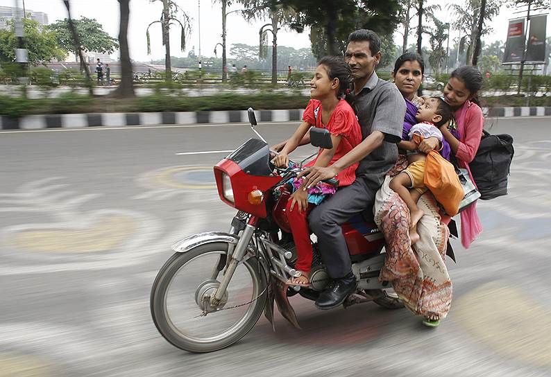 Мужчина со своей семьей на мотоцикле в Дакке, Бангладеш