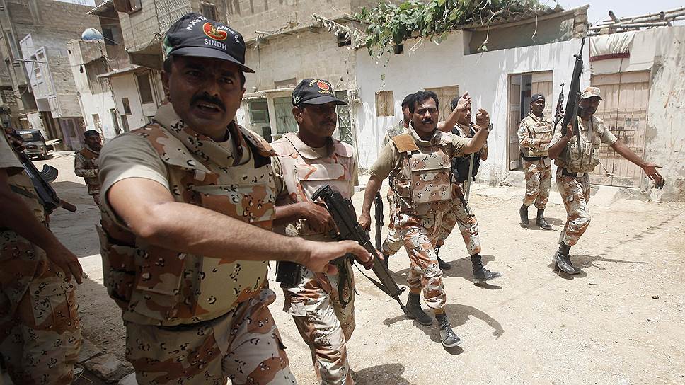 Пакистанские солдаты просят журналистов освободить им путь во время прочесывания одного из районов Карачи в поисках талибов, ответственных за недавнюю атаку в аэропорте города
