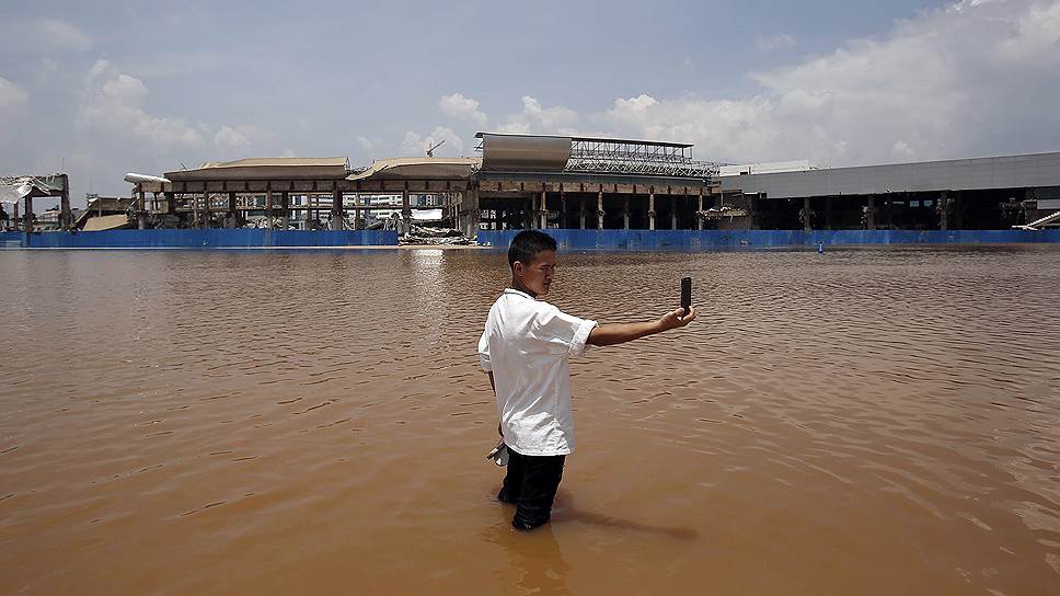 Местный житель делает селфи в затопленной зоне провинции Юньнань, Китай
