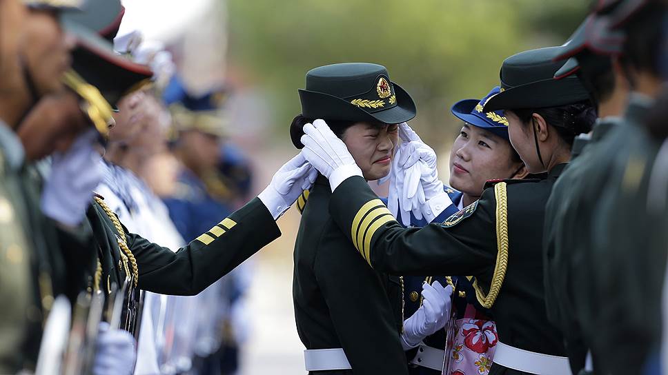Женщины, служащие в почетном карауле, поправляют форму перед церемонией встречи премьер-министра Италии Маттео Ренци, прибывшего с визитом в Пекин