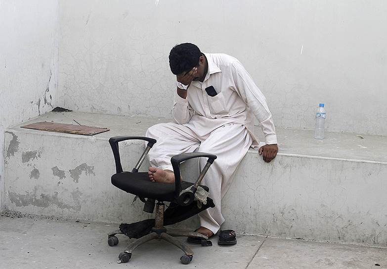 Мужчина оплакивает смерть своего родственника, убитого во время атаки талибов на аэропорт в воскресенье, у морга в Карачи (Пакистан)