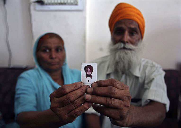 Гурмит Каур и Балдев Сингх показывают фотографию их сына Гурмукха Сингха, одного из сорока индийских рабочих, похищенных в иракском Мосуле, находящемся под контролем боевиков «Исламского государства Ирака и Шама»