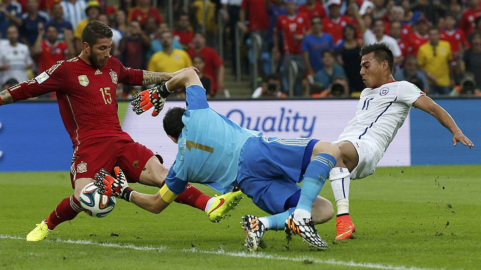 Футболист сборной Чили Эдуардо Варгас (справа) забивает гол в обход вратаря сборной Испании Икера Касильяса (в центре)