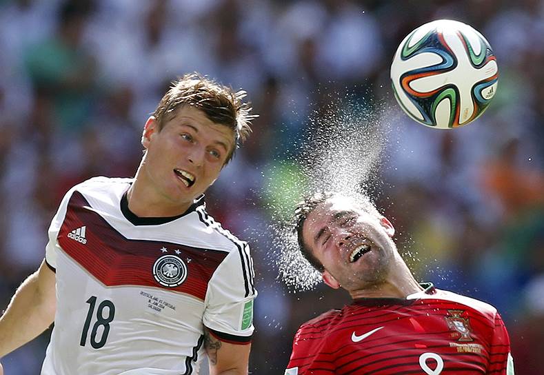 Полузащитник сборной Германии Тони Кроос (слева) и португальский футболист Жоао Моутиньо сражаются за мяч