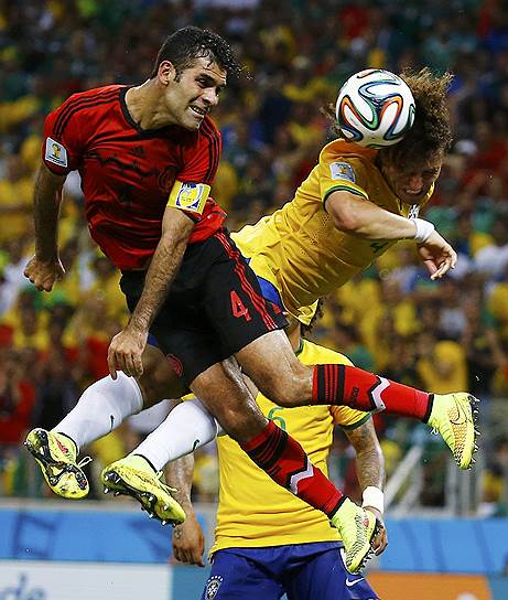 Защитник сборной Мексики Рафаэль Маркес (слева) и футболист сборной Бразилии Давид Луиз сражаются за мяч