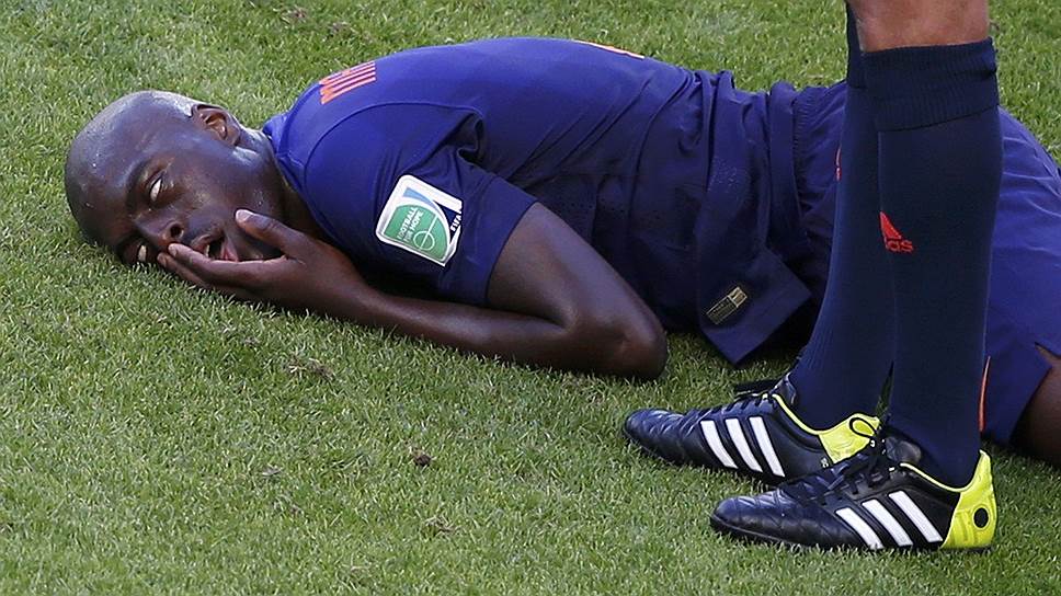 Футболист сборной Нидерландов Бруно Мартинс Инди лежит на поле после удара, полученного от австралийца Тима Кэхилла