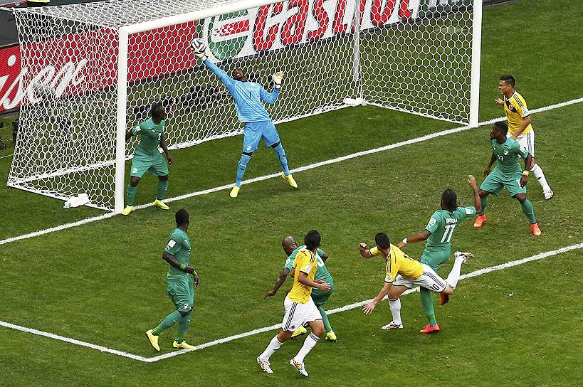 Вратарь сборной Кот-д&#39;Ивуара Бубакар Барри (в воротах) пропускает гол, забитый футболистом сборной Колумбии Джеймсом Родригесом (внизу в центре)