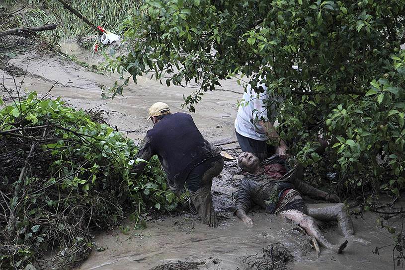 Прохожие помогают мужчине, пострадавшему во время наводнения в Варне, Болгария