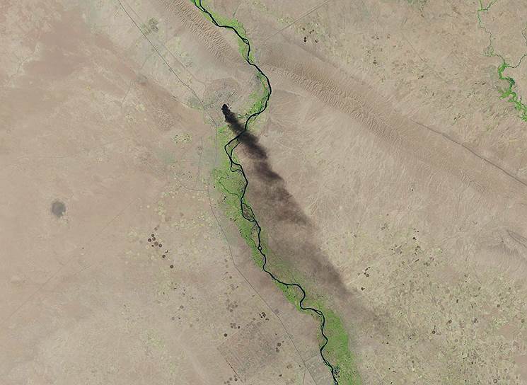 Дым, идущий от нефтеперегонного завода неподалеку от Тикрита, Ирак