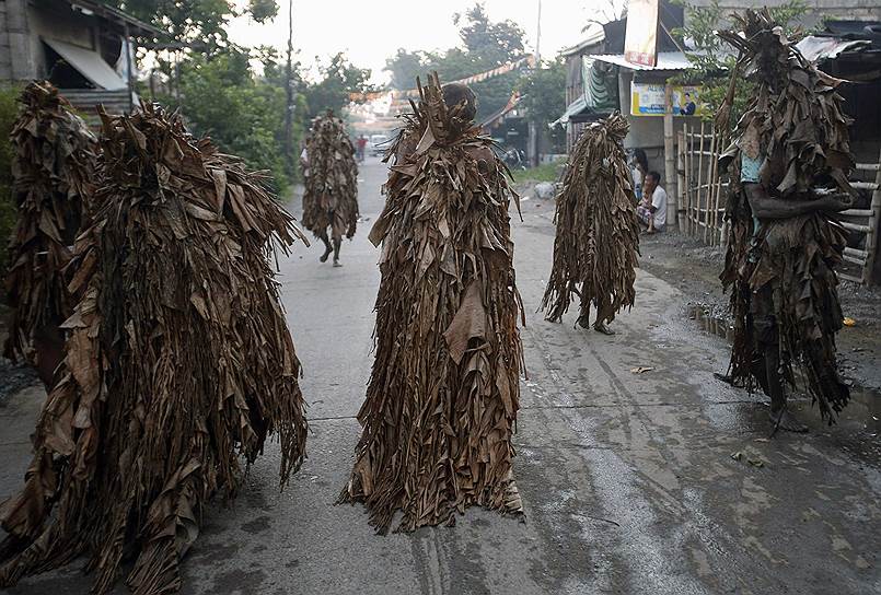 Местные жители, одетые в банановые листья и вымазанные грязью, во время празднования дня святого Иоанна на Филиппинах