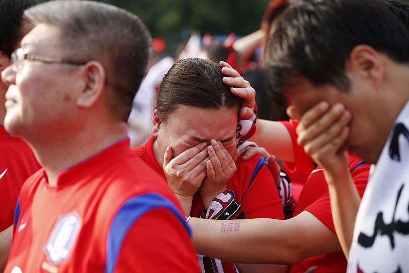 Южнокорейские футбольные фанаты после того, как их команда потерпела поражение от сборной Бельгии
