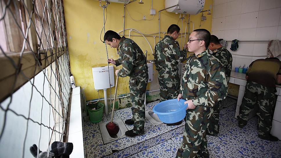 Во время пребывания в лагере подростки принимают участие в учениях армейского типа, занимаются уборкой помещений, помогают готовить еду&lt;br> На фото: Ван (слева), один из подростков с интернет-зависимостью, помогает мыть туалеты в лагере