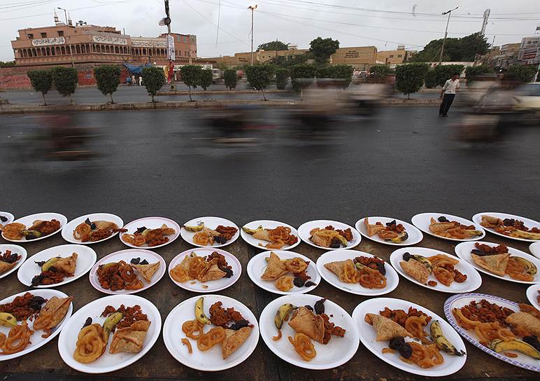 Тарелки с едой на дороге в пакистанском городе Карачи