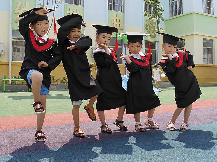 Выпускники детского сада позируют для фотографии в китайской провинции Хэнань