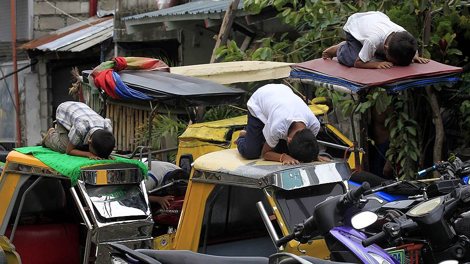 Молодые филиппинские мусульмане молятся на крышах такси во время Рамадана