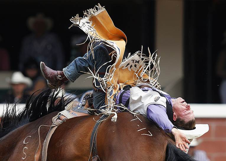 Мэтт Лайт, один из участников родео в канадском городе Калгари, пытается удержаться на лошади по кличке Твин Черри 