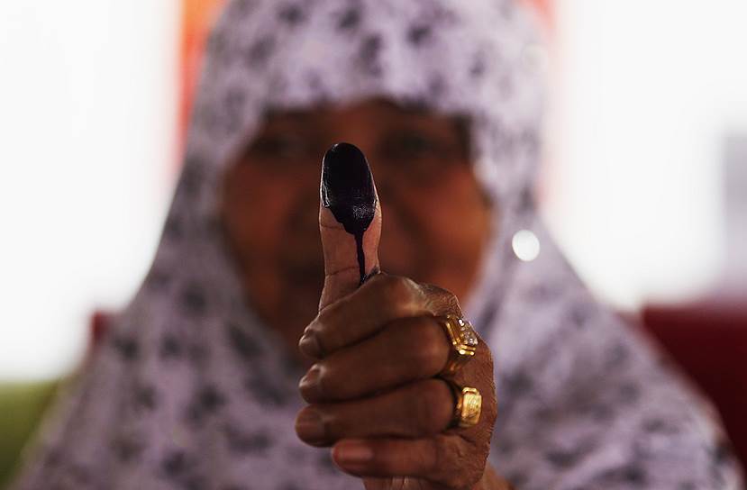 Женщина после голосования на президентских выборах на избирательном участке в Богоре, Индонезия