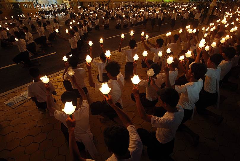 Люди держат факелы перед Королевским дворцом в Пномпене во время церемонии, посвященной умершему королю Камбоджи Нородому Сиануку