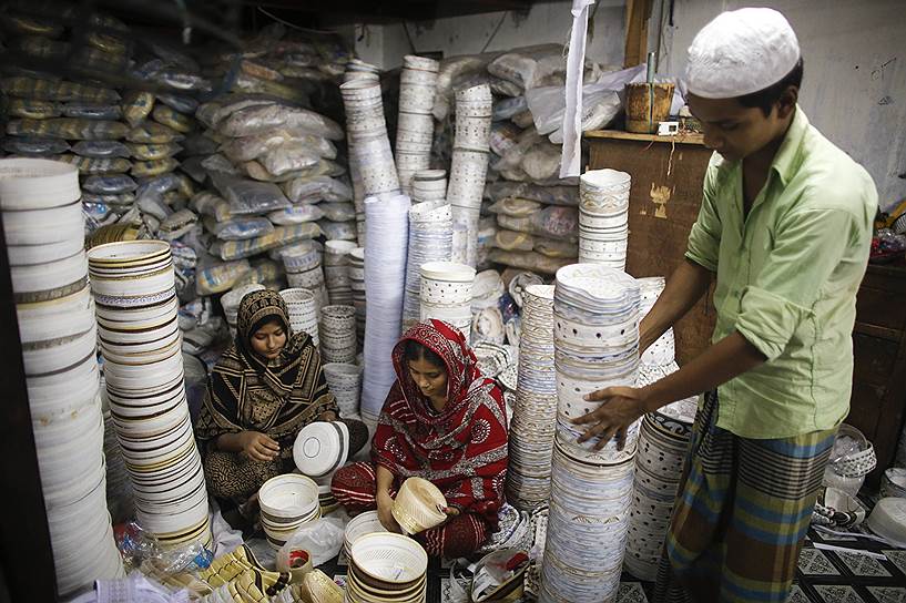 Рабочие на заводе в Дакке, Бангладеш, шьют молитвенные головные уборы, которые пользуются большим спросом во время священного месяца Рамадан