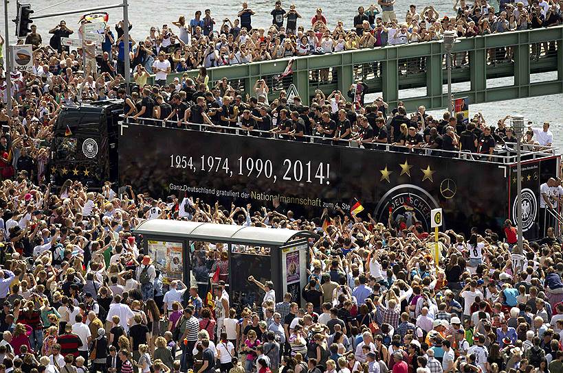 Прямо на взлетной полосе футболисты погрузились в специально подогнанный чемпионский автобус с открытой крышей, на котором команда триумфально въехала в Берлин
