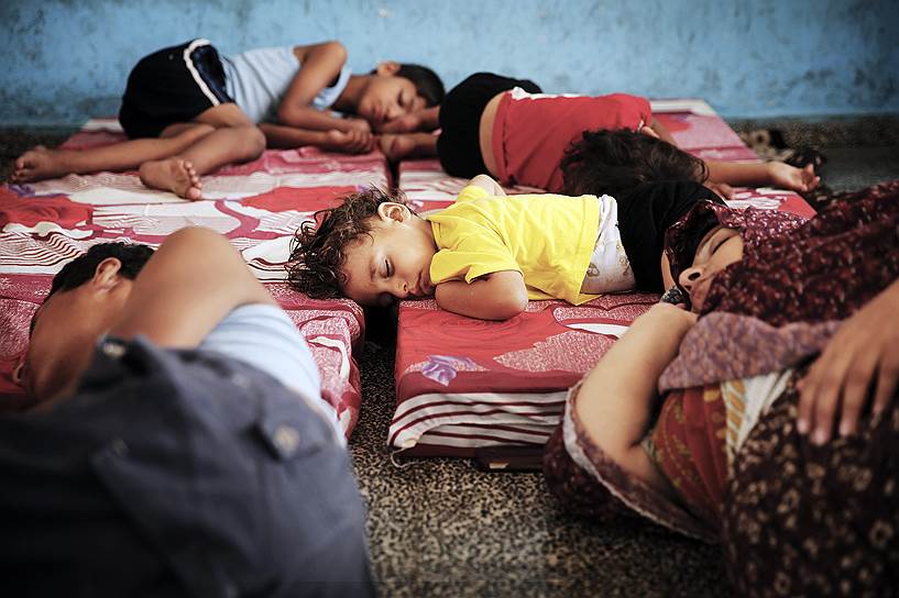 Палестинские дети спят в убежище, предоставленном ООН, на случай ракетных ударов в Газе