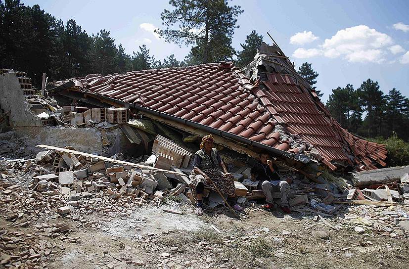 Женщина сидит перед своим домом в цыганском районе города Стара-Загора в Болгарии, разрушенном в рамках борьбы властей с незаконно возведенными постройками