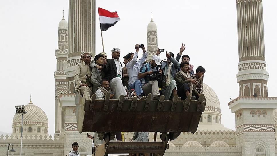 Люди в ковше бульдозера во время похорон генерала армии Йемена Хамида аль-Кушаиби в Сане