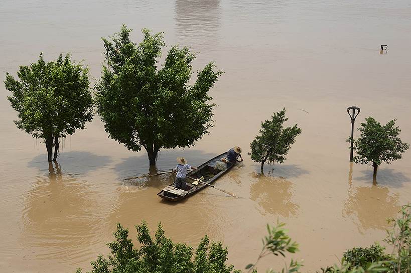 Местные жители ловят рыбу в вышедшей из берегов реке в Наньнине, Гуанси-Чжуанский автономный район Китая