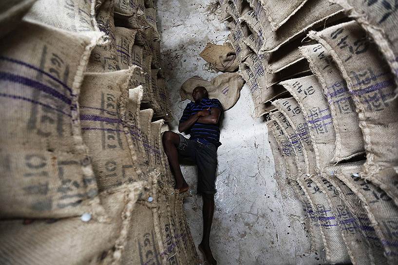 Рабочий на складе какао-бобов в Дабиссо, Гана